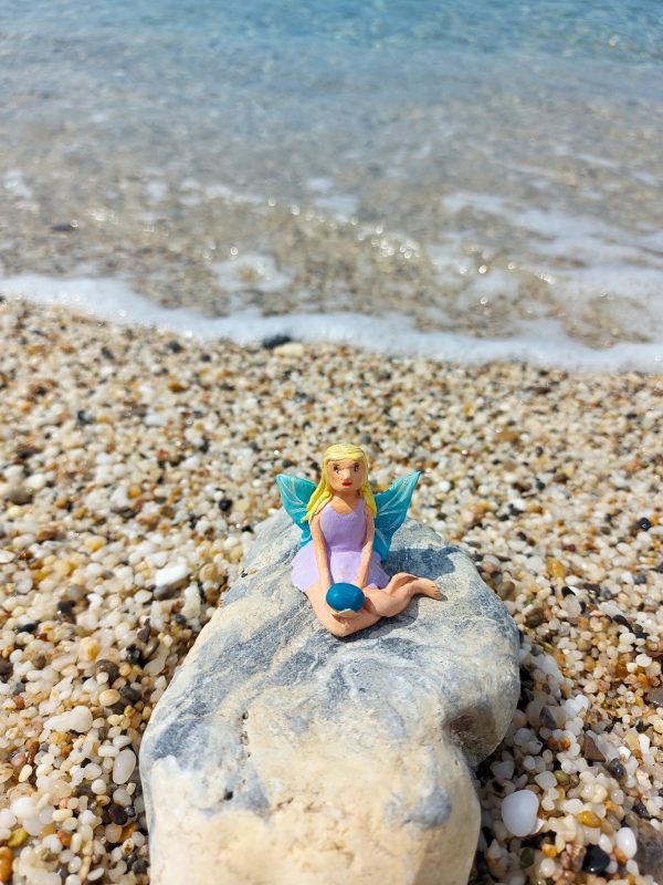 Handmade polymer clay fairy miniature holding a blue magic rock