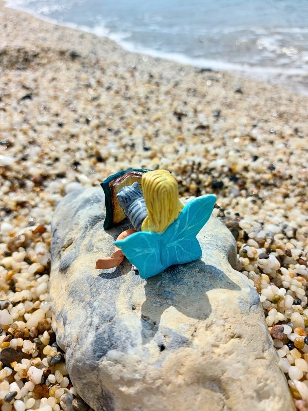 Handmade fairy miniature displayed with other clay miniatures in a whimsical setting