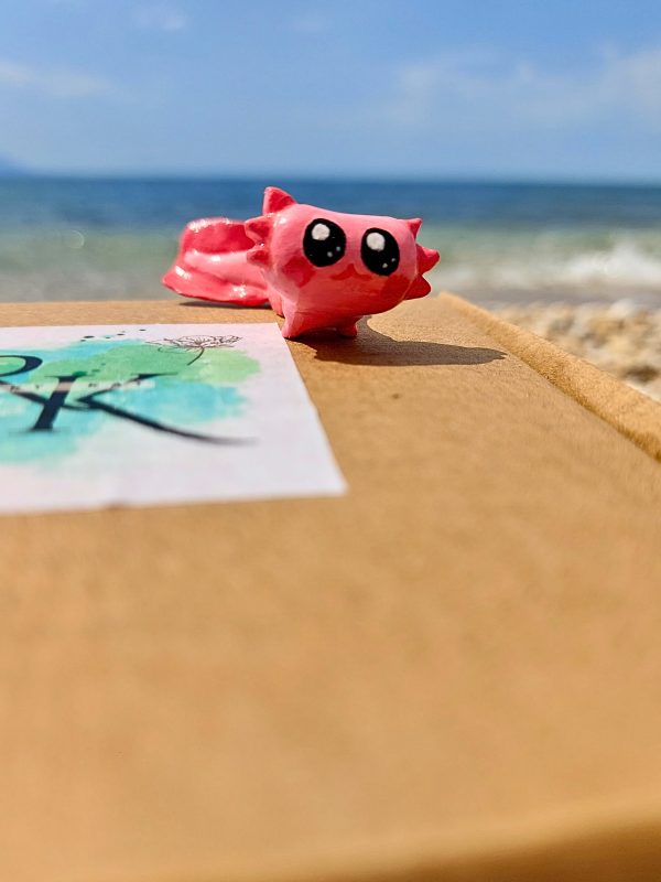 Close-up of Handmade Pink Axolotl Miniature with Hand-Painted Details on our box